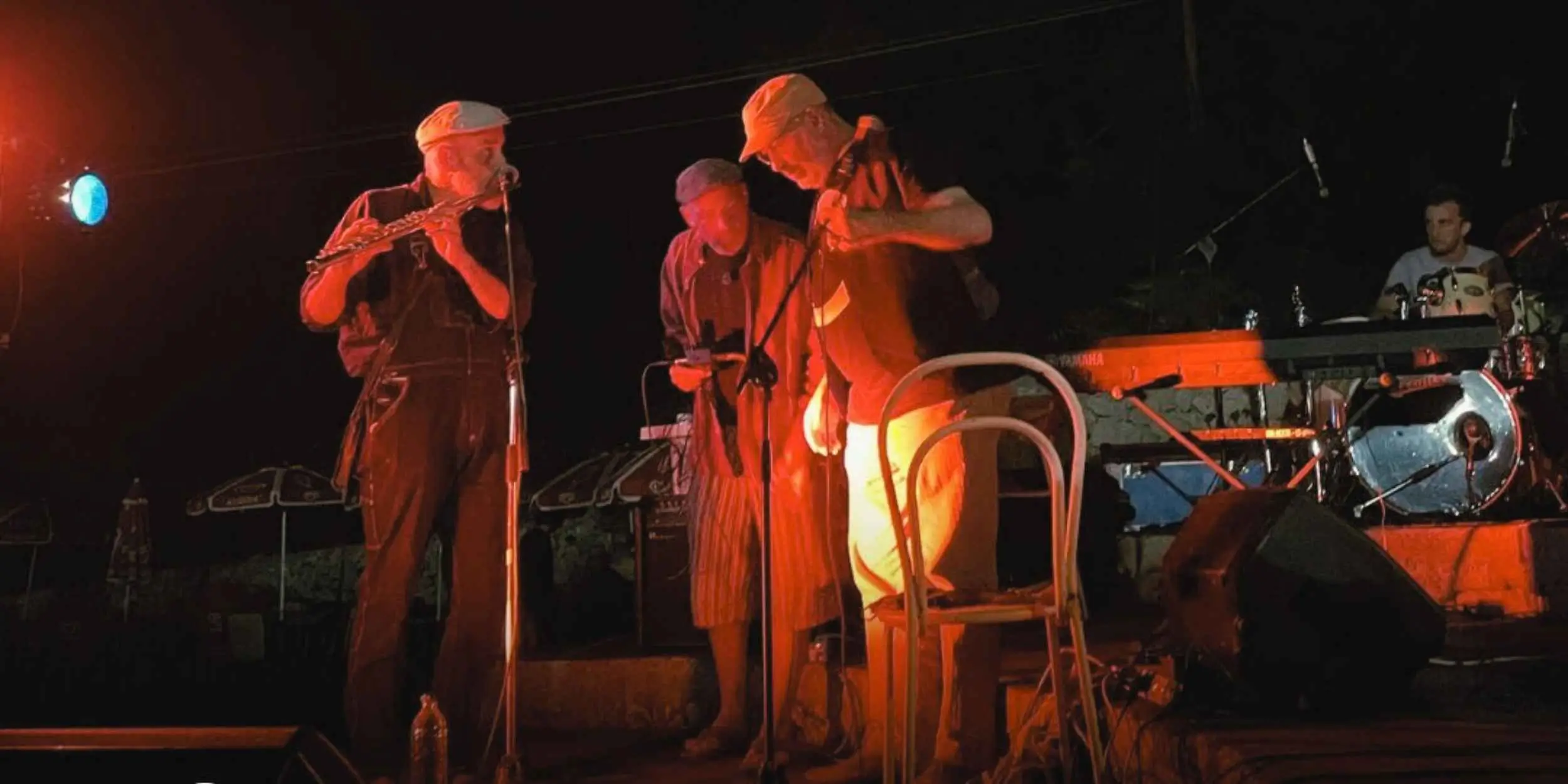 Concerto serale al RARA Festival 2025 a Palazzolo Acreide in Sicilia, con musicisti di musica improvvisata e arti performative sul palco.